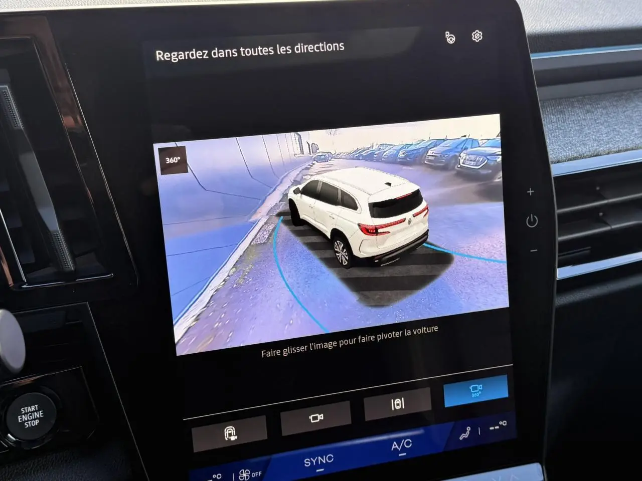 Écran tactile montrant la vue 360° d'un Renault Espace noir étoilé en recul dans un parking extérieur.