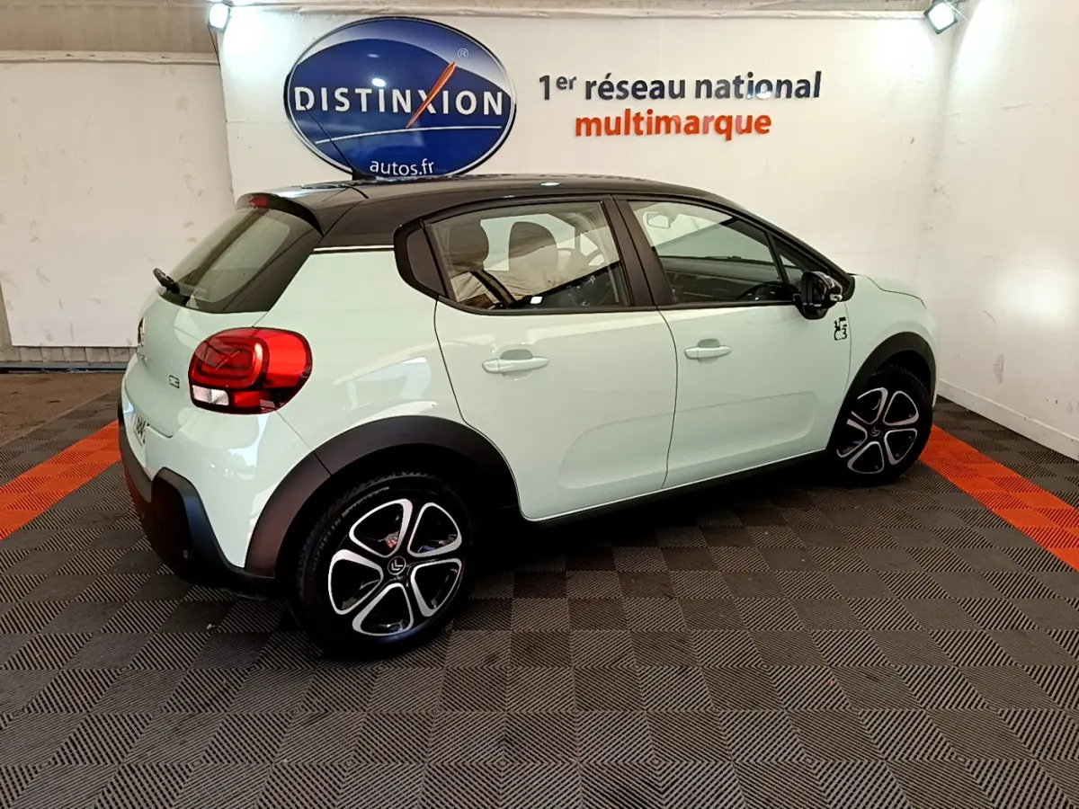 Vue latérale droite d'une Citroën C3 PureTech 82 vert clair avec toit noir et jantes distinctives en concession.