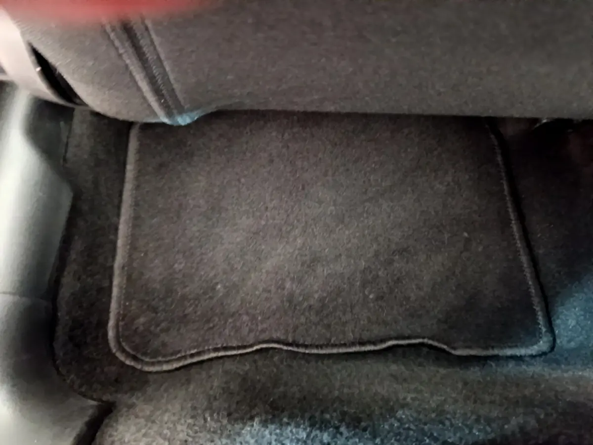 Vue rapprochée du tapis de sol noir sous le siège arrière d'une Citroën C3 vert 2019.