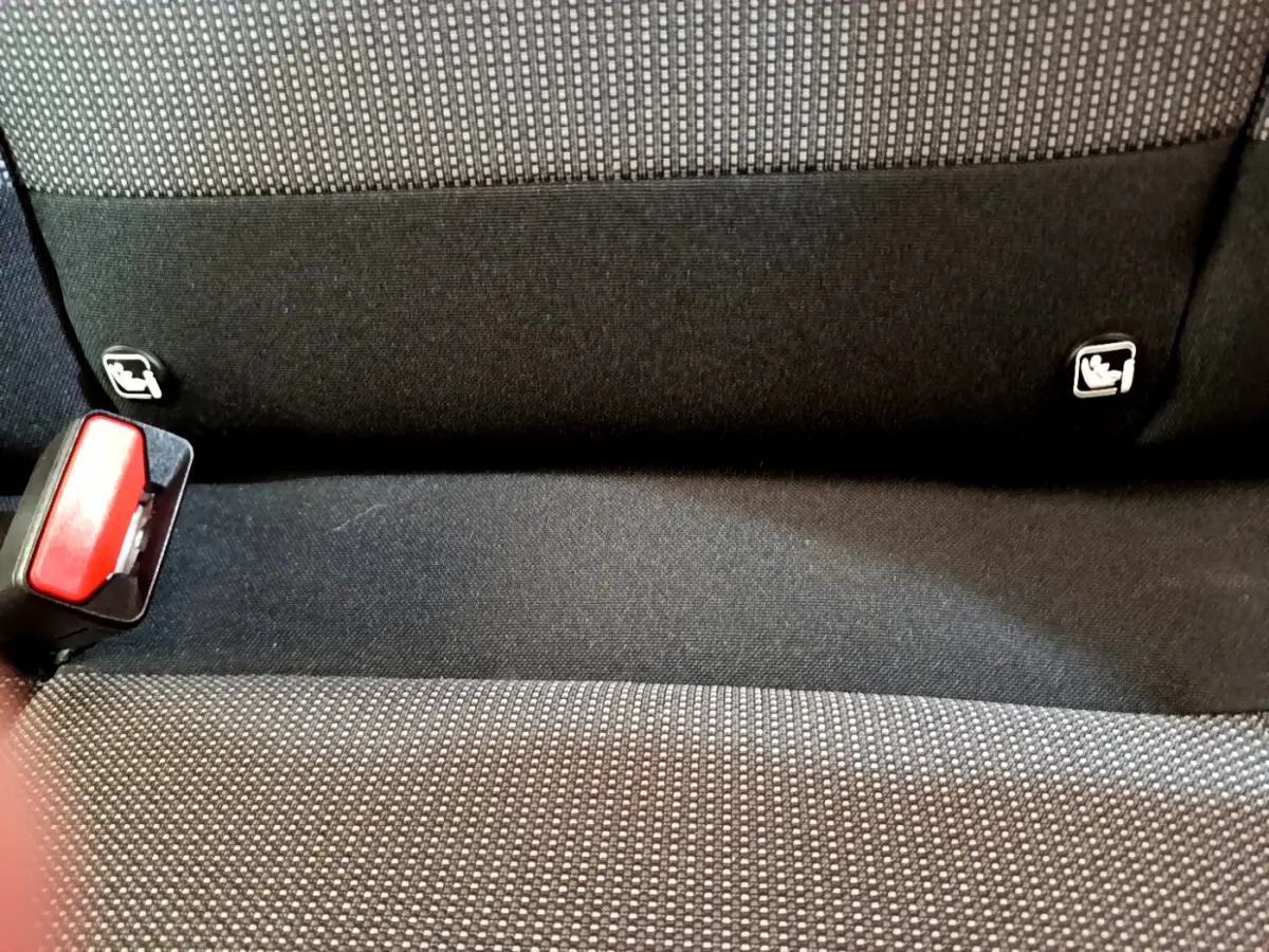 Gros plan sur la banquette arrière noire et grise de la Citroën C3 avec fixation Isofix et boucle de ceinture rouge visible.
