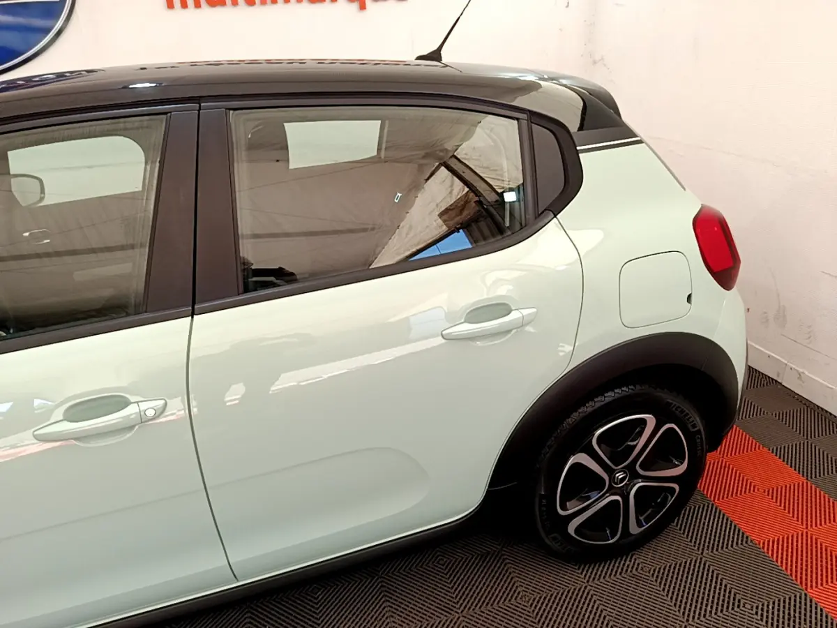 Vue latérale droite d'une Citroën C3 PureTech 82 vert clair avec toit noir et jantes stylisées.