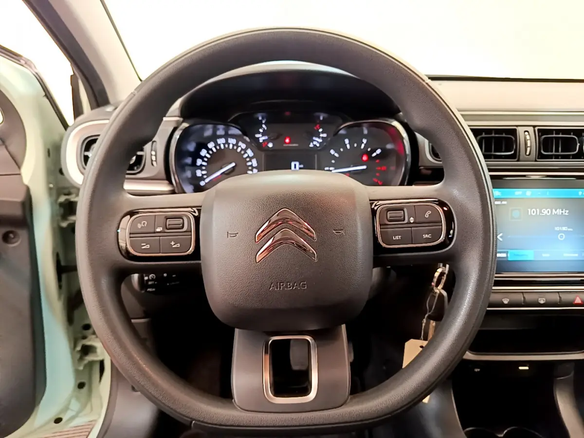 Vue rapprochée du volant multifonctions noir d'une Citroën C3 2019 avec tableau de bord et écran tactile visible.