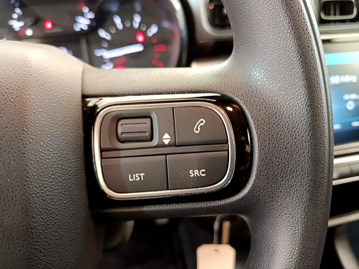 Gros plan sur les commandes gauche du volant noir de la Citroën C3 PureTech 82 S&S BVM Graphic 2019.