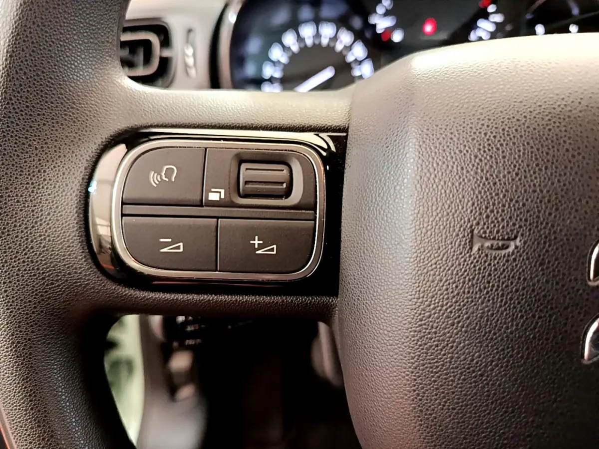 Gros plan sur les commandes gauche du volant noir du Citroën C3 PureTech 82 S&S BVM Graphic 2019.