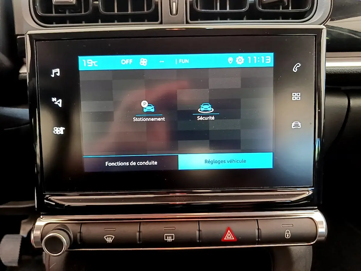 Écran tactile central de la Citroën C3 PureTech 82 vert, affichant les options de stationnement et sécurité.