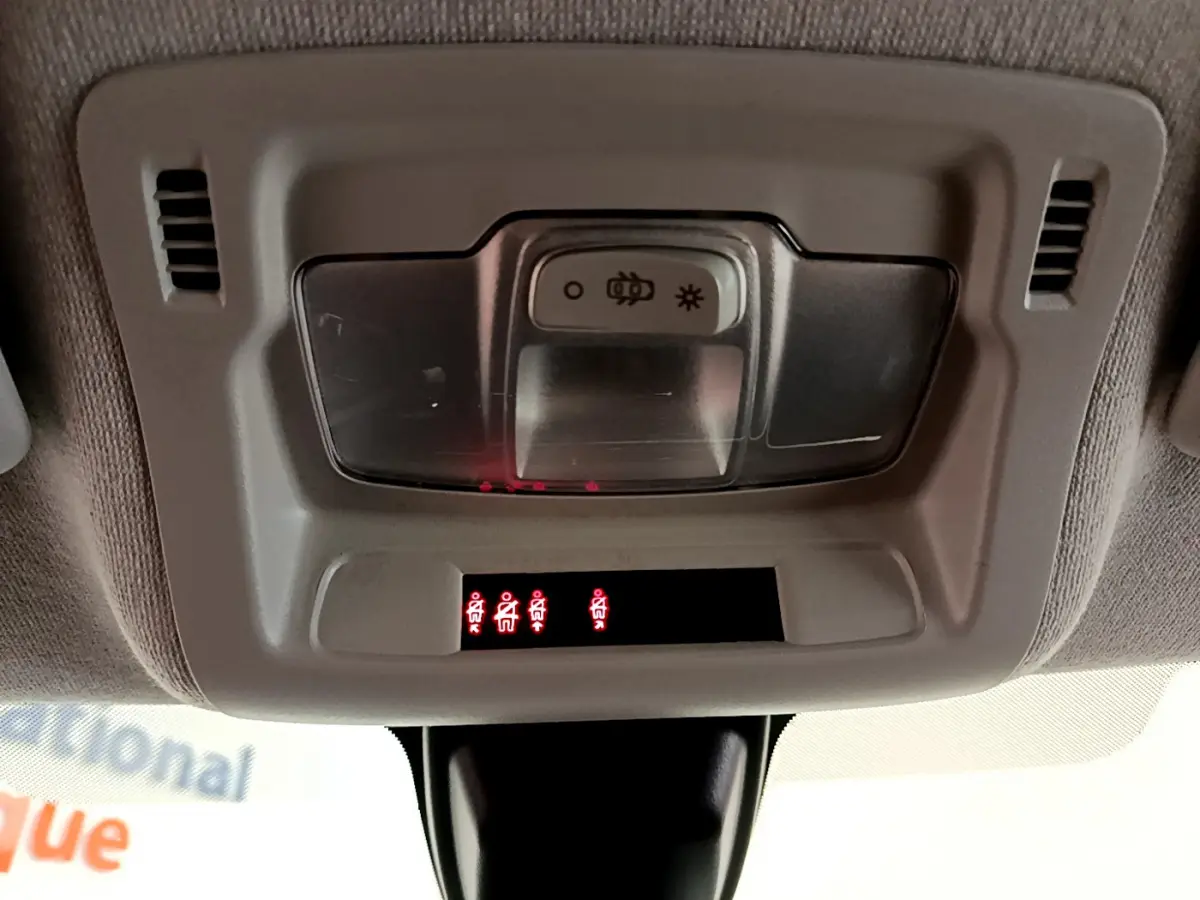 Vue intérieure du plafonnier gris clair de la Citroën C3 avec témoins de ceinture allumés en rouge.
