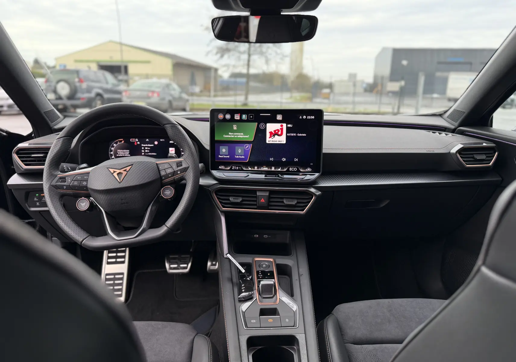 Vue intérieure avant du CUPRA Formentor 1.5 eHybrid 2025, tableau de bord noir avec écran tactile central et volant multifonction.