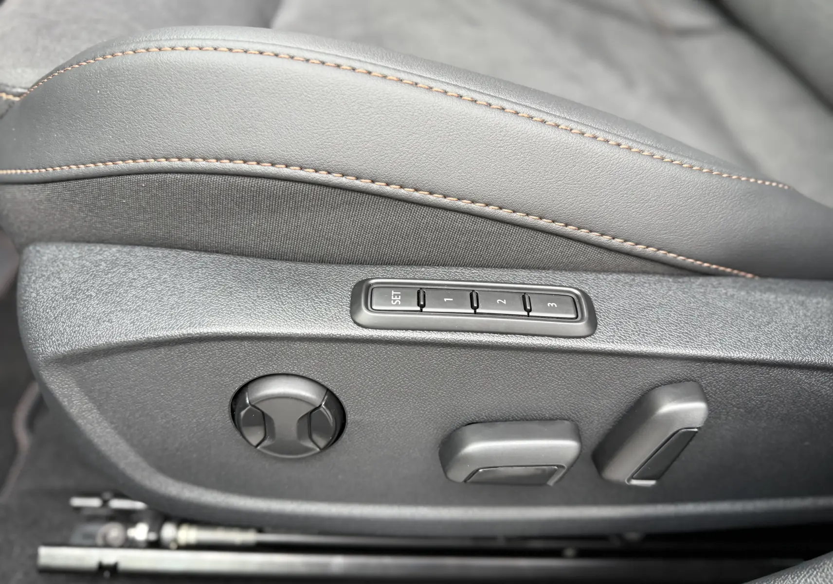 Détail des commandes de réglage électrique du siège avant avec surpiqûres contrastantes dans une CUPRA Formentor noir minuit.