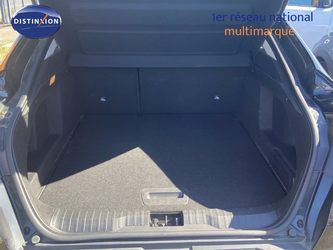Coffre ouvert vu de l'arrière d'un Renault Arkana noir métal, espace de chargement vide et propre.
