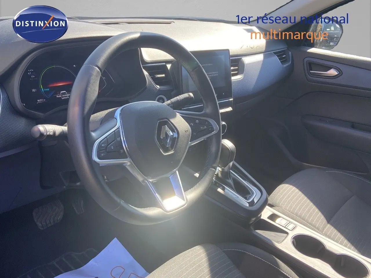 Vue intérieure côté conducteur du Renault Arkana hybride 2023, volant multifonction et console centrale avec boîte automatique.