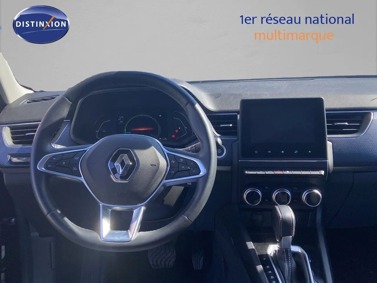 Vue intérieure centrée sur le volant et la console centrale d'une Renault Arkana noire, avec écran tactile et commandes visibles.