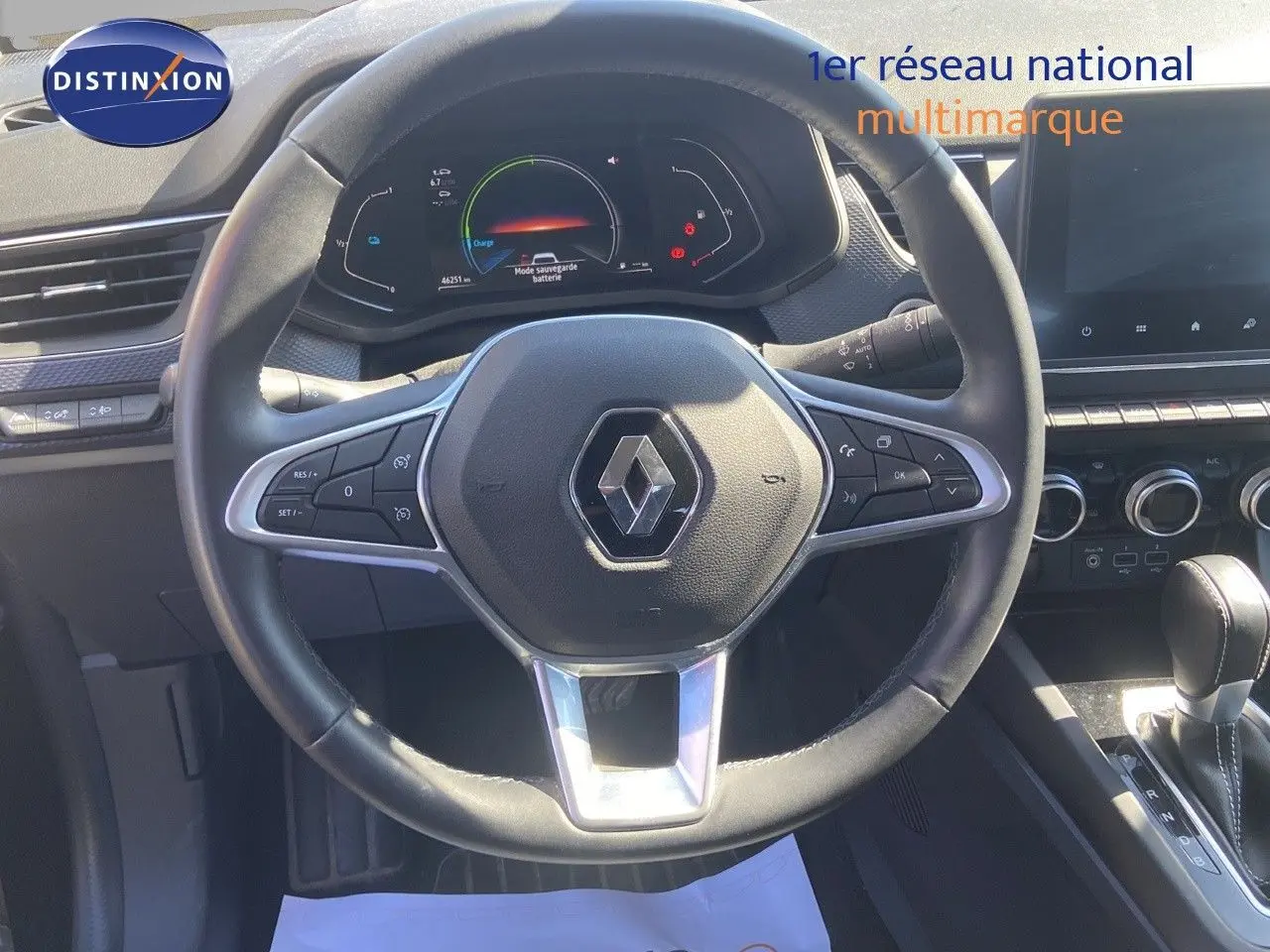 Vue rapprochée du volant noir du Renault Arkana 2023 avec tableau de bord numérique et commandes intégrées.
