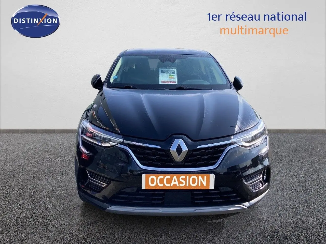 Vue avant d'une Renault Arkana noire métal 2023 avec calandre chromée et phares LED allumés.