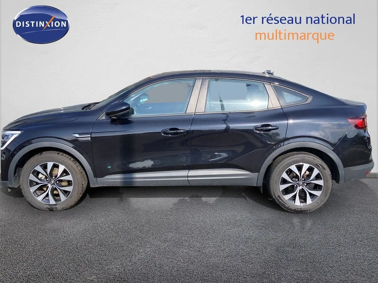 Profil côté gauche d'un Renault Arkana noir métal 2023 avec jantes bi-ton et lignes fluides de SUV coupé.