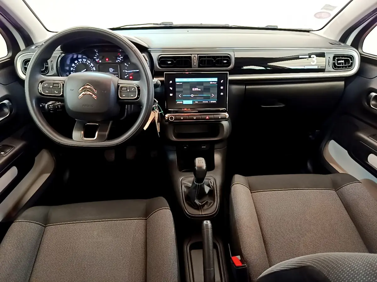Intérieur de la Citroën C3 PureTech 82 blanc, vue de face sur le tableau de bord et la console centrale avec écran tactile.