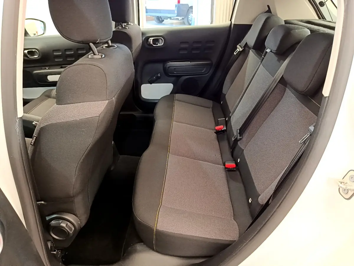 Vue intérieure côté droit sur la banquette arrière grise et noire du Citroën C3 blanc de 2019.