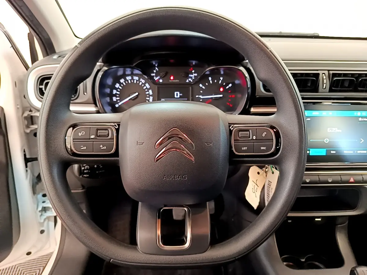 Vue rapprochée du volant noir de la Citroën C3 blanche 2019 avec tableau de bord et écran tactile visible à droite.