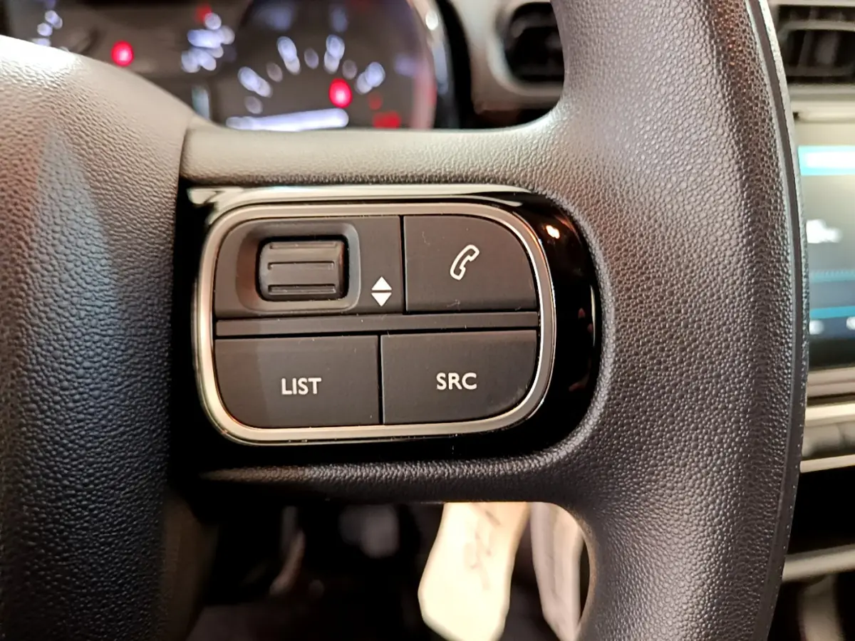 Gros plan sur les commandes gauche du volant noir de la Citroën C3 PureTech 82 S&S BVM Graphic 2019.