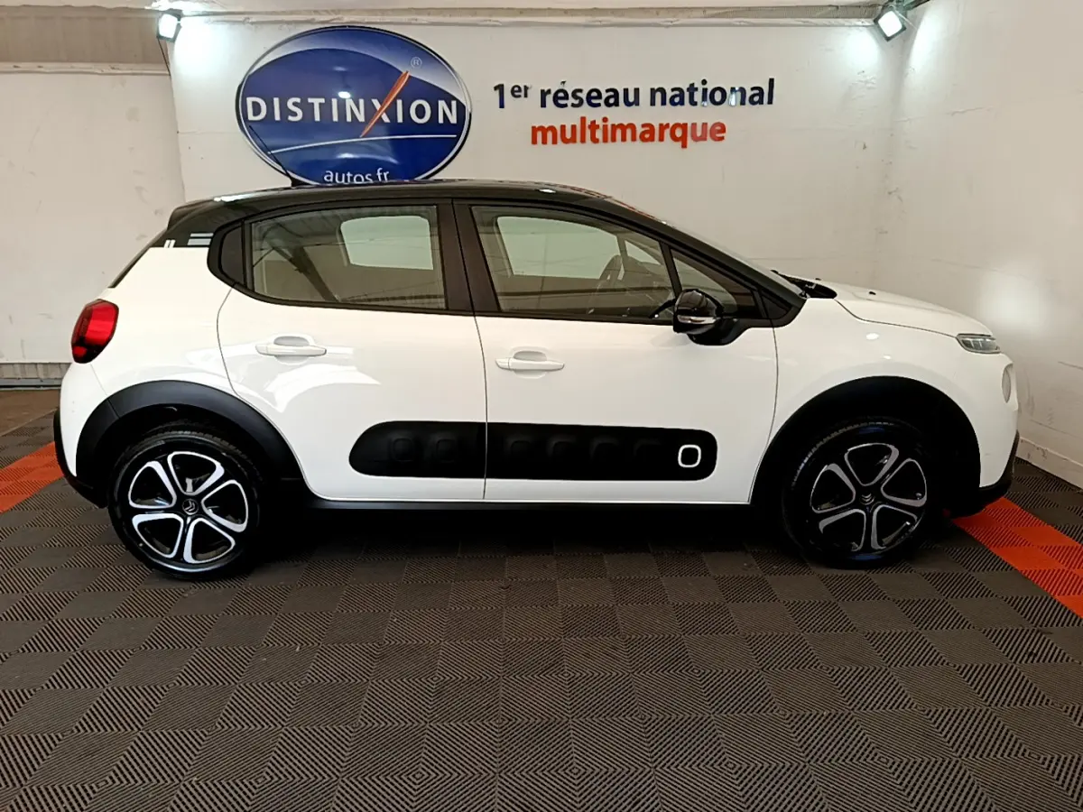 Profil côté gauche d'une Citroën C3 blanche 2019 avec toit noir et protections latérales noires distinctives.