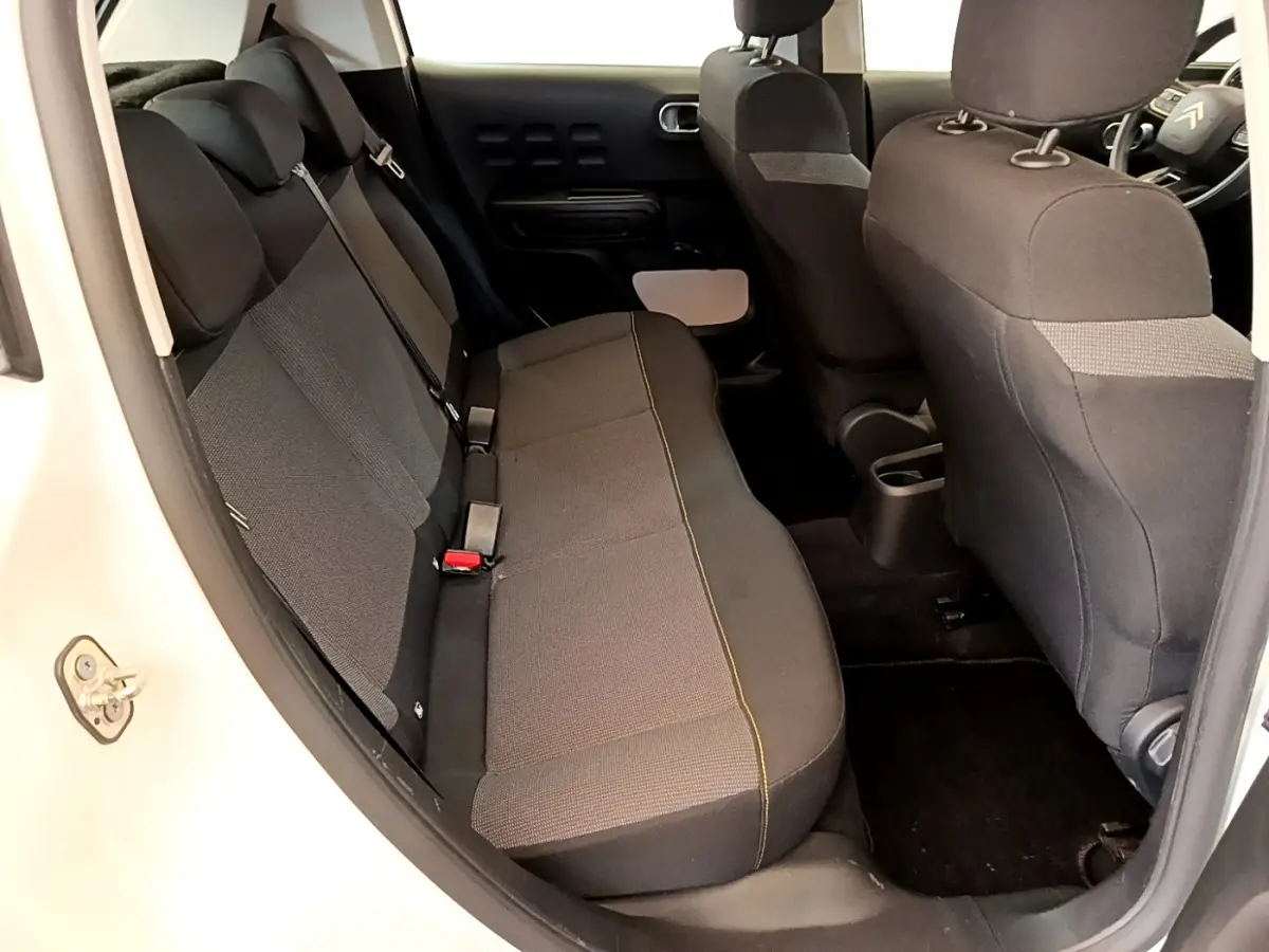 Vue intérieure côté gauche montrant la banquette arrière noire d'une Citroën C3 blanche de 2019.
