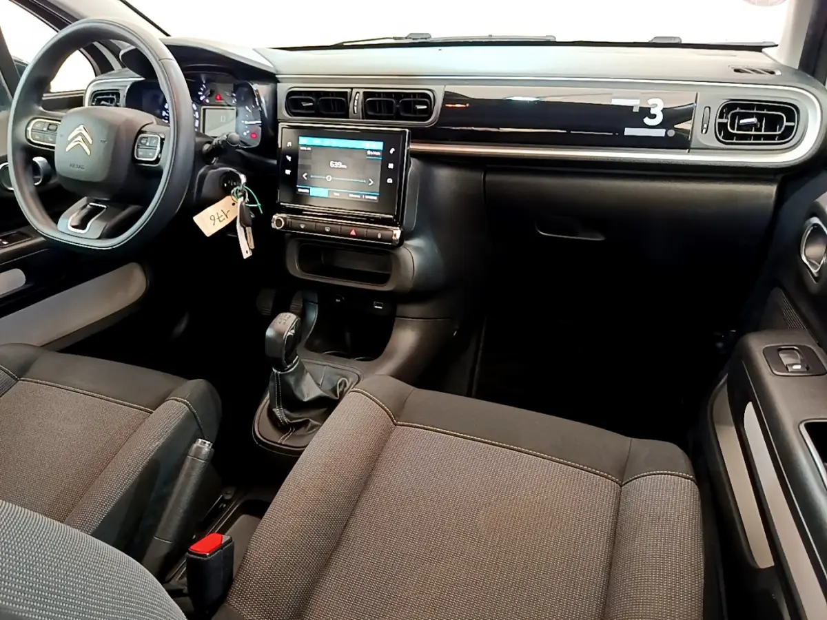 Intérieur avant de la Citroën C3 blanche 2019, vue côté conducteur, tableau de bord avec écran tactile et volant multifonctions.