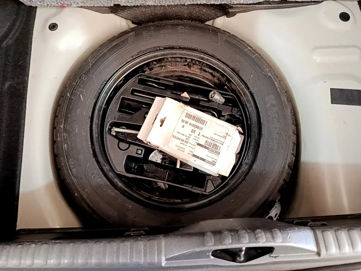 Roue de secours noire dans le coffre blanc d'une Citroën C3 PureTech 82 S&S BVM Graphic 2019.