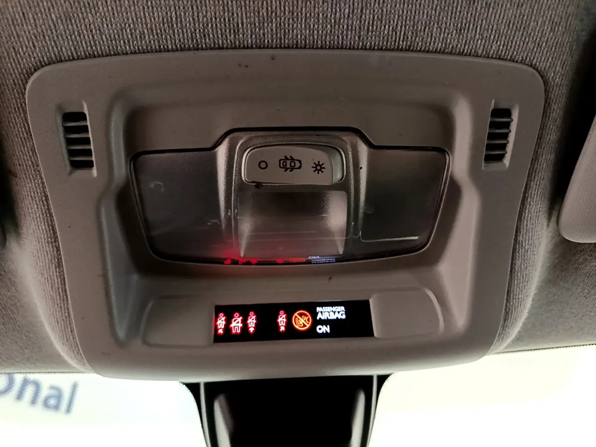 Vue en gros plan du plafonnier gris avec commandes d'éclairage et indicateurs d'airbags de la Citroën C3 blanche 2019.