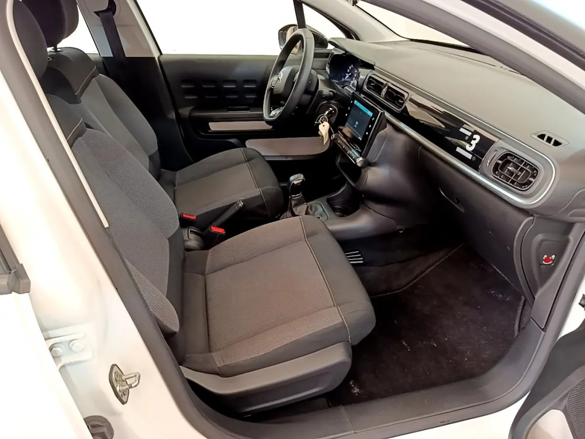 Intérieur de la Citroën C3 blanc, vue côté droit, sièges noirs et tableau de bord avec écran tactile central.