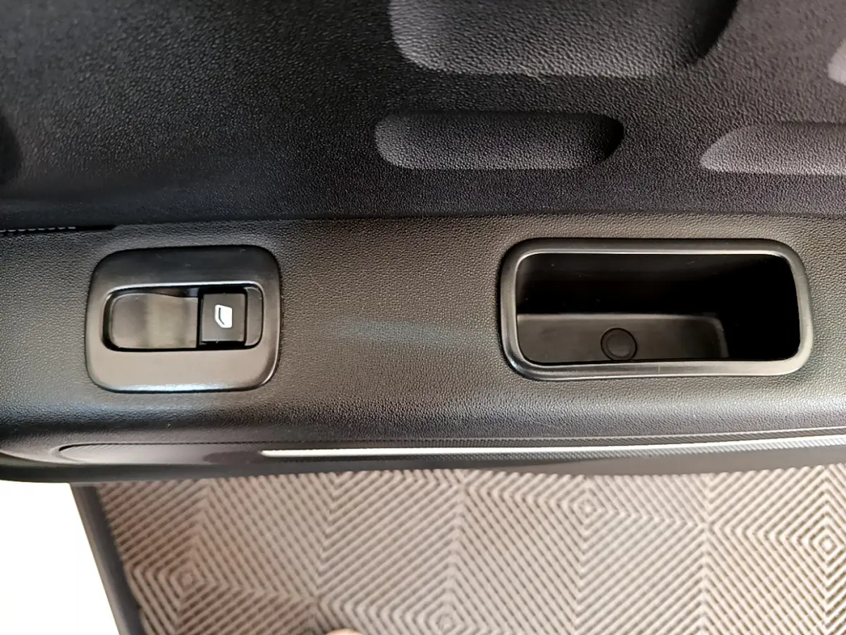 Gros plan sur la poignée intérieure et bouton de lève-vitre côté gauche de la porte d'une Citroën C3 blanche de 2019.