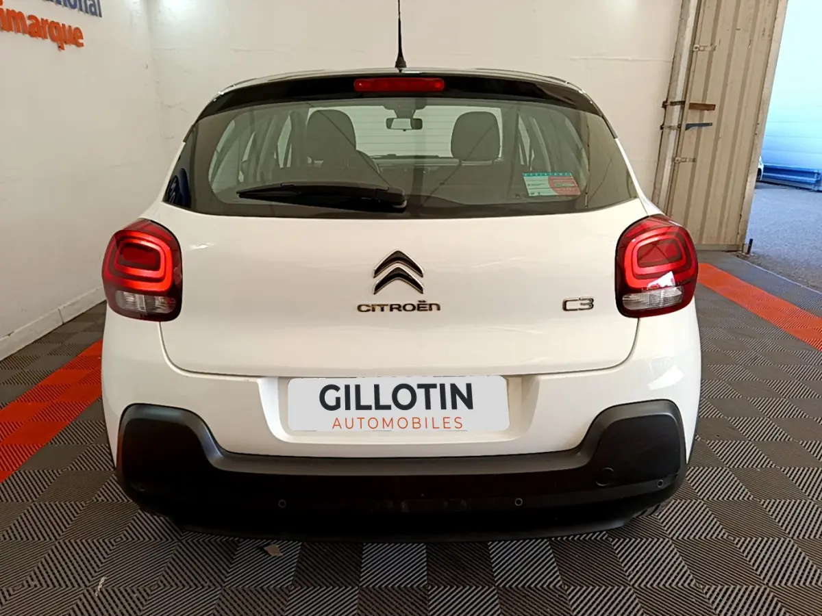 Vue arrière d'une Citroën C3 blanche de 2019 avec feux arrière LED et logo centré sur un fond noir.