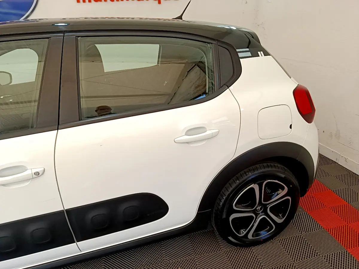 Vue latérale droite d'une Citroën C3 blanche avec protections noires et jantes au design distinctif.