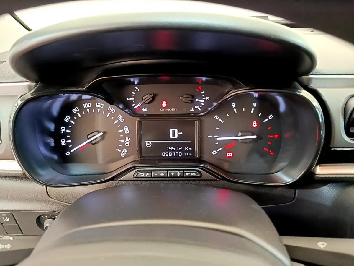 Tableau de bord de Citroën C3 PureTech 82 blanc, vue frontale centrée sur les compteurs numériques et analogiques.