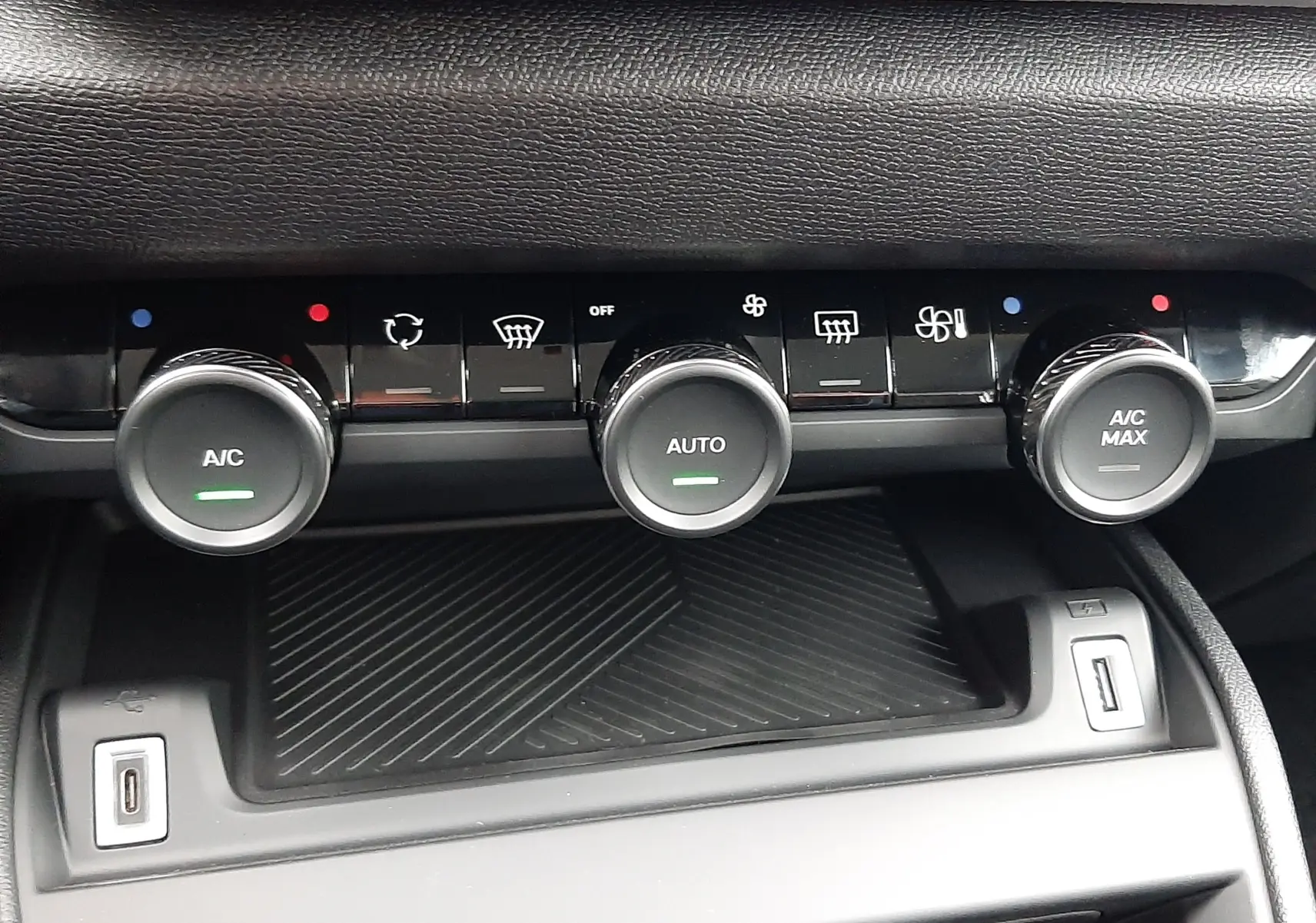 Gros plan sur la console centrale du Citroën C4 2025 blanc Okenite avec commandes climatisation et ports USB visibles.