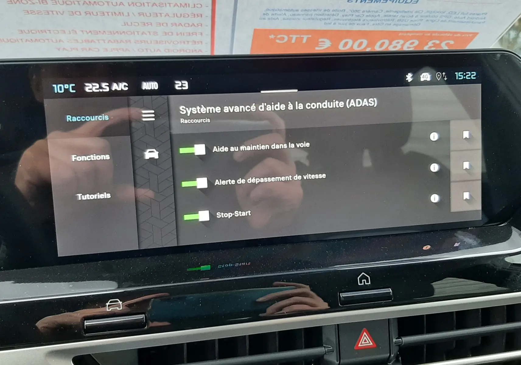 Vue intérieure de l'écran tactile du tableau de bord de la Citroën C4 blanche avec toit noir, affichant les aides à la conduite activées.