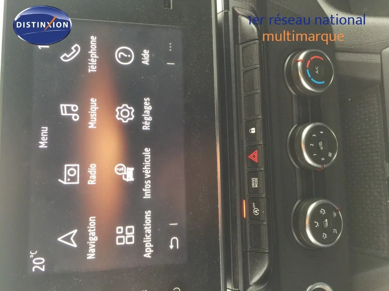 Vue rapprochée de la console centrale du Renault Kangoo blanc 2023, avec écran tactile et commandes de climatisation.