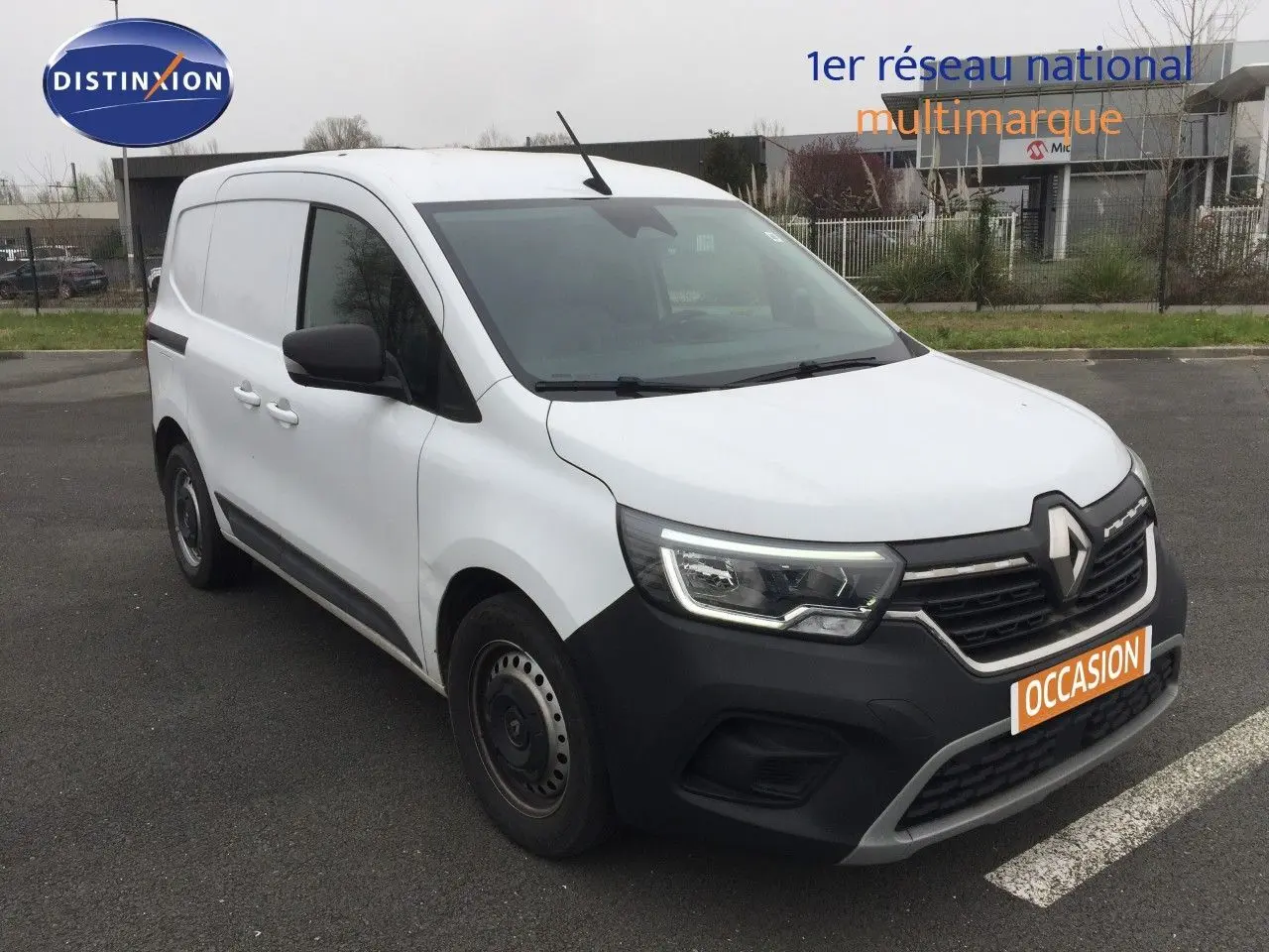 Vue 3/4 avant gauche d’un Renault Kangoo Extra blanc 2023 avec pare-chocs noir et jantes tôles simples.