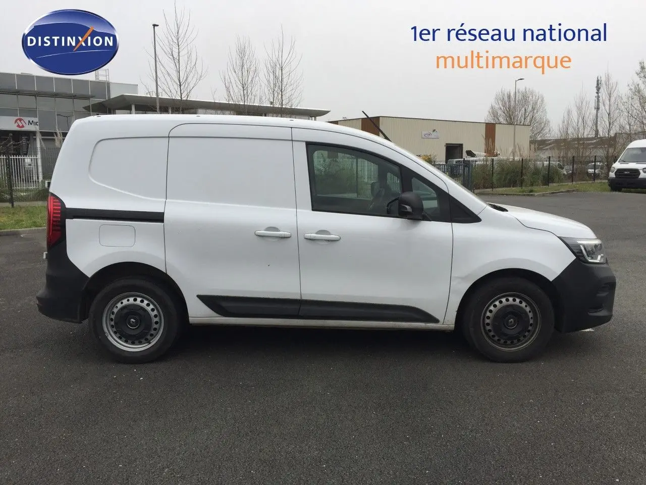 Profil côté gauche d'un Renault Kangoo Extra blanc 2023 avec pare-chocs noirs et jantes acier simples.