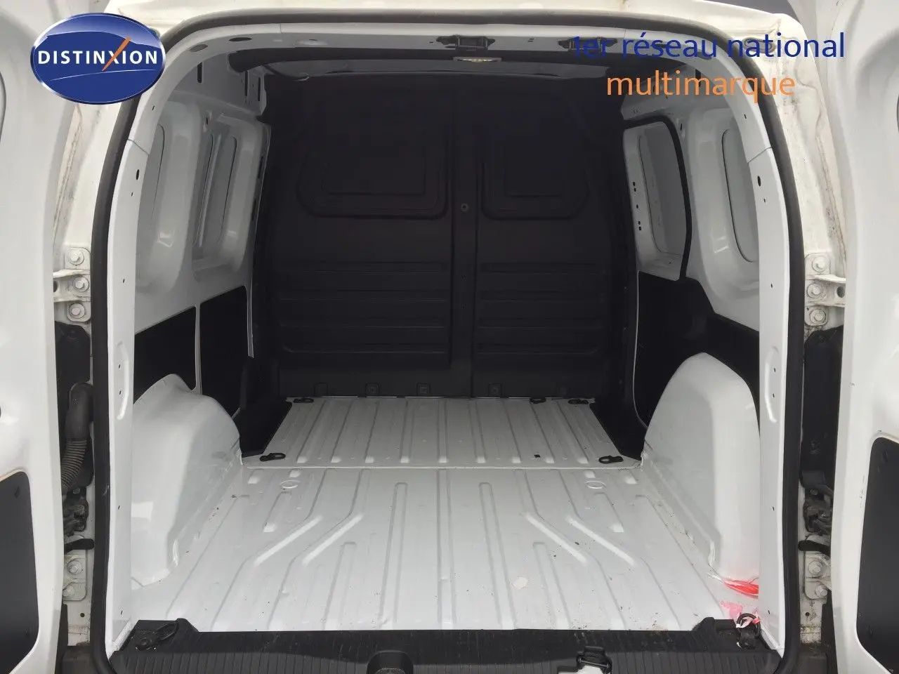 Vue arrière intérieure du Renault Kangoo Extra blanc 2023, montrant l'espace de chargement vide et les parois métalliques.