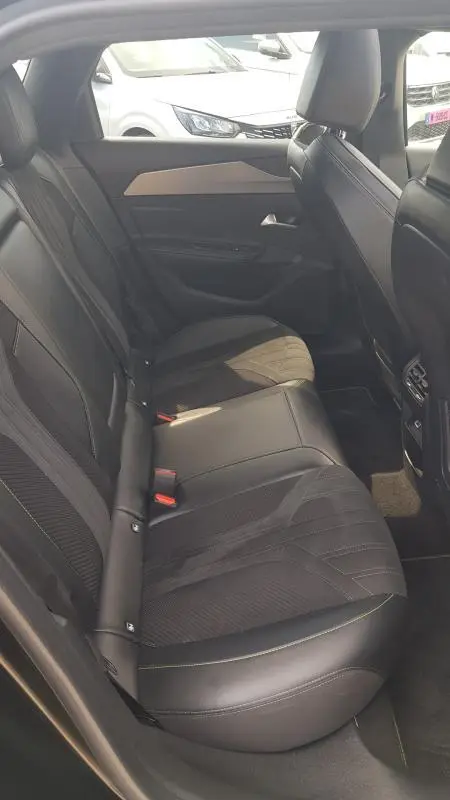 Vue intérieure côté droit des sièges arrière en cuir noir du Peugeot 308 SW PHEV 225 e-EAT8 GT 2023 avec finitions modernes.