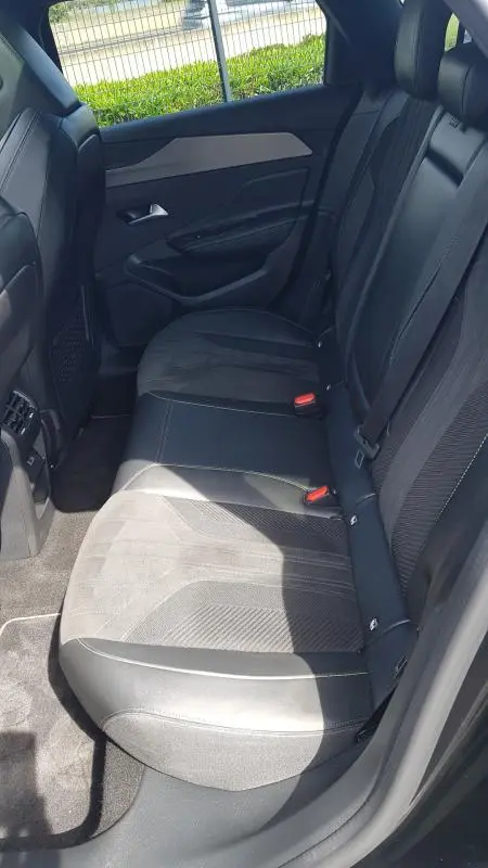 Vue intérieure côté droit des sièges arrière noirs en cuir et tissu du Peugeot 308 SW PHEV 225 e-EAT8 GT 2023.