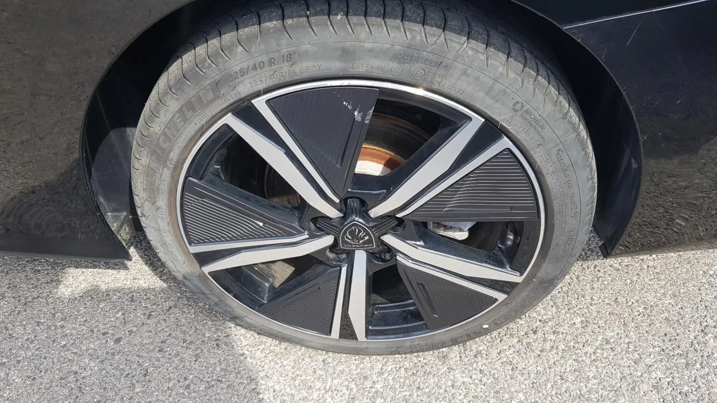 Gros plan sur la jante alliage noire et argentée de 18 pouces d'une Peugeot 308 SW PHEV 225 e-EAT8 GT noire.