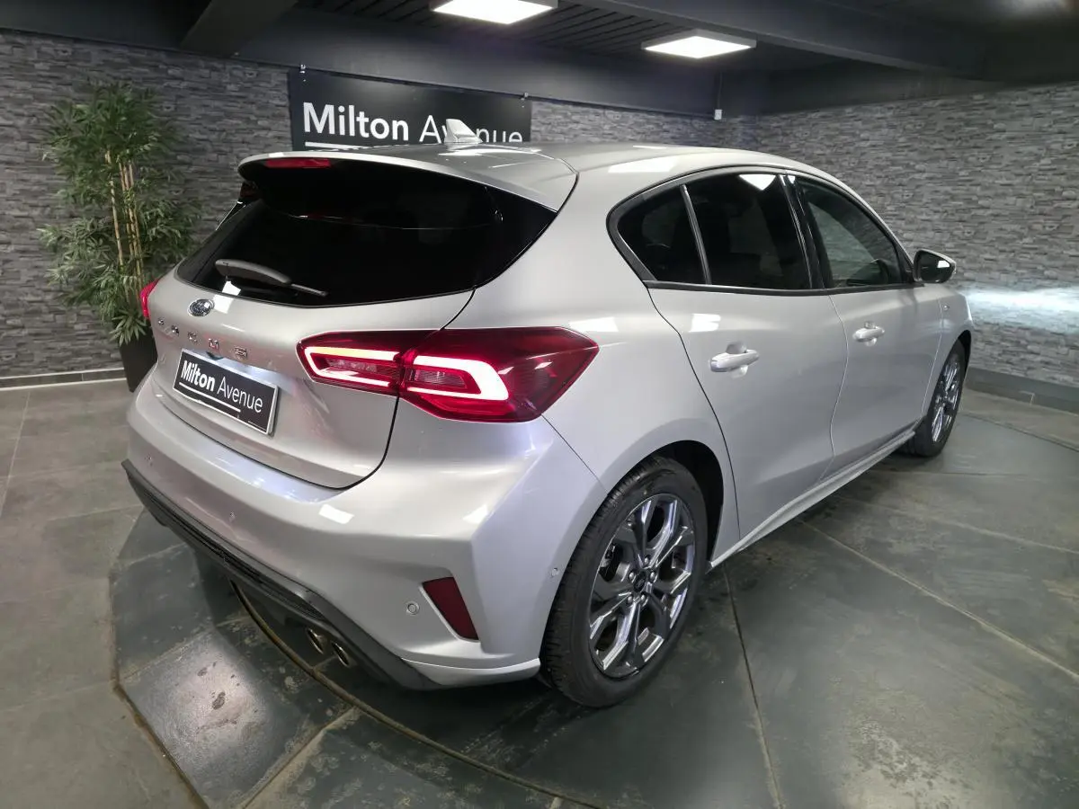 Vue 3/4 arrière droite d'une Ford Focus gris lunaire 2024 avec feux arrière LED et jantes alliage 17 pouces.