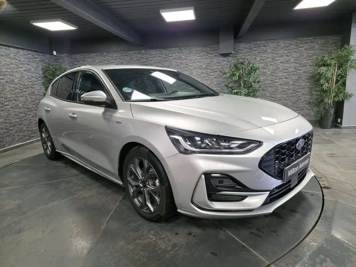 Vue 3/4 avant droite de la Ford Focus 2024 gris lunaire avec calandre noire et jantes alliage 17 pouces.