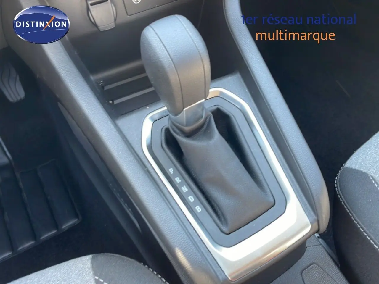 Le levier de vitesse automatique en gros plan dans l'habitacle sombre d'une Renault Clio hybride 2025.