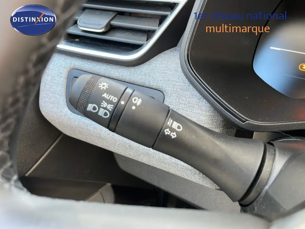 Gros plan sur la commande des feux et clignotants dans l’habitacle de la Renault Clio blanche Glacier 2025.