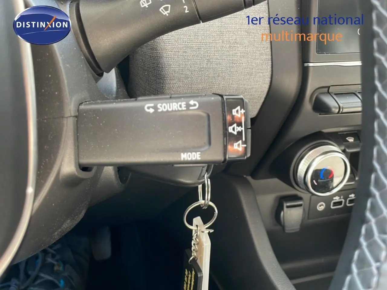 Détail intérieur du volant de la Renault Clio hybride 2025, montrant la commande multimédia et la clé suspendue.