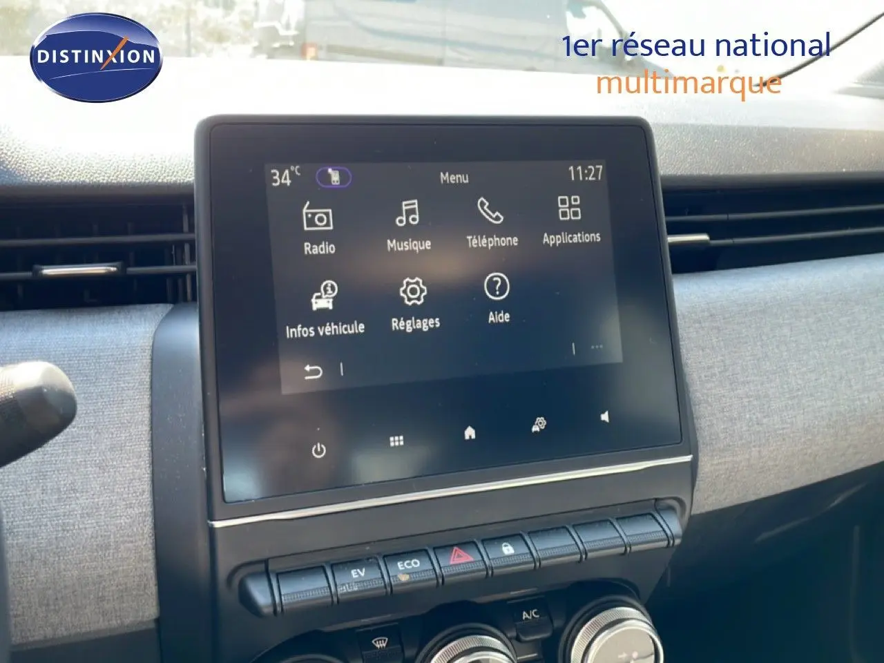 Vue rapprochée de l’écran tactile central et des commandes de la Renault Clio blanche Glacier, version hybride 2025.