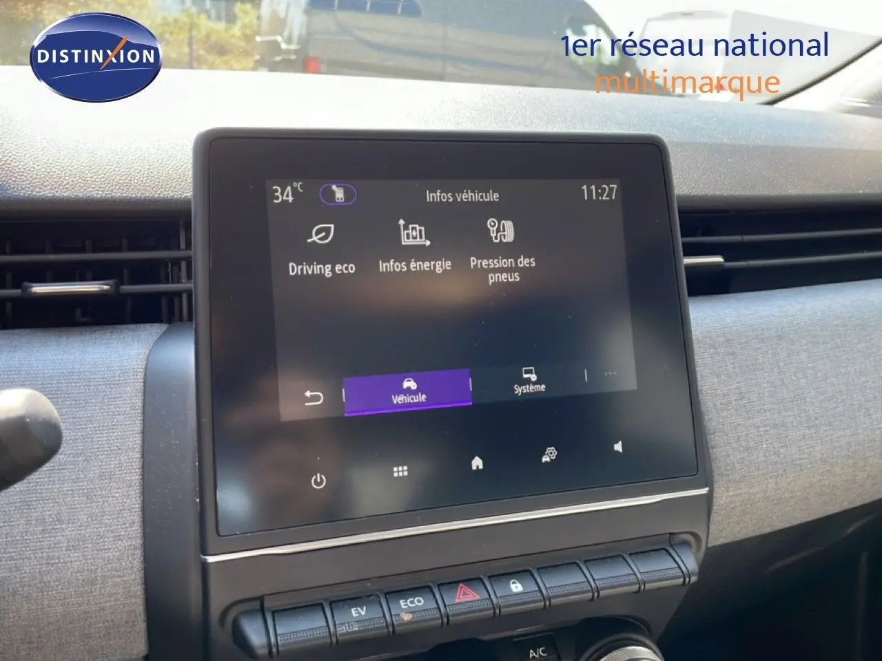 Écran tactile central du tableau de bord de la Renault Clio blanche, affichant les infos véhicule en intérieur.