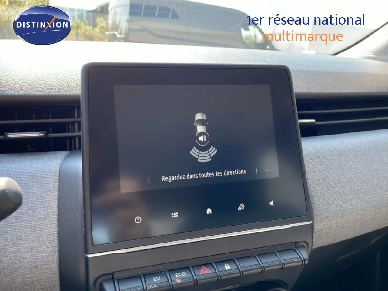 Écran tactile central de la Renault Clio blanche 2025 affichant une alerte de surveillance des angles morts.