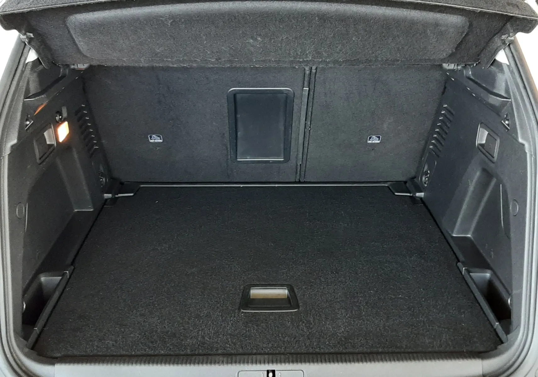 Coffre ouvert vu de l'arrière d'un Peugeot 3008 blanc, montrant un espace de chargement propre et bien agencé.